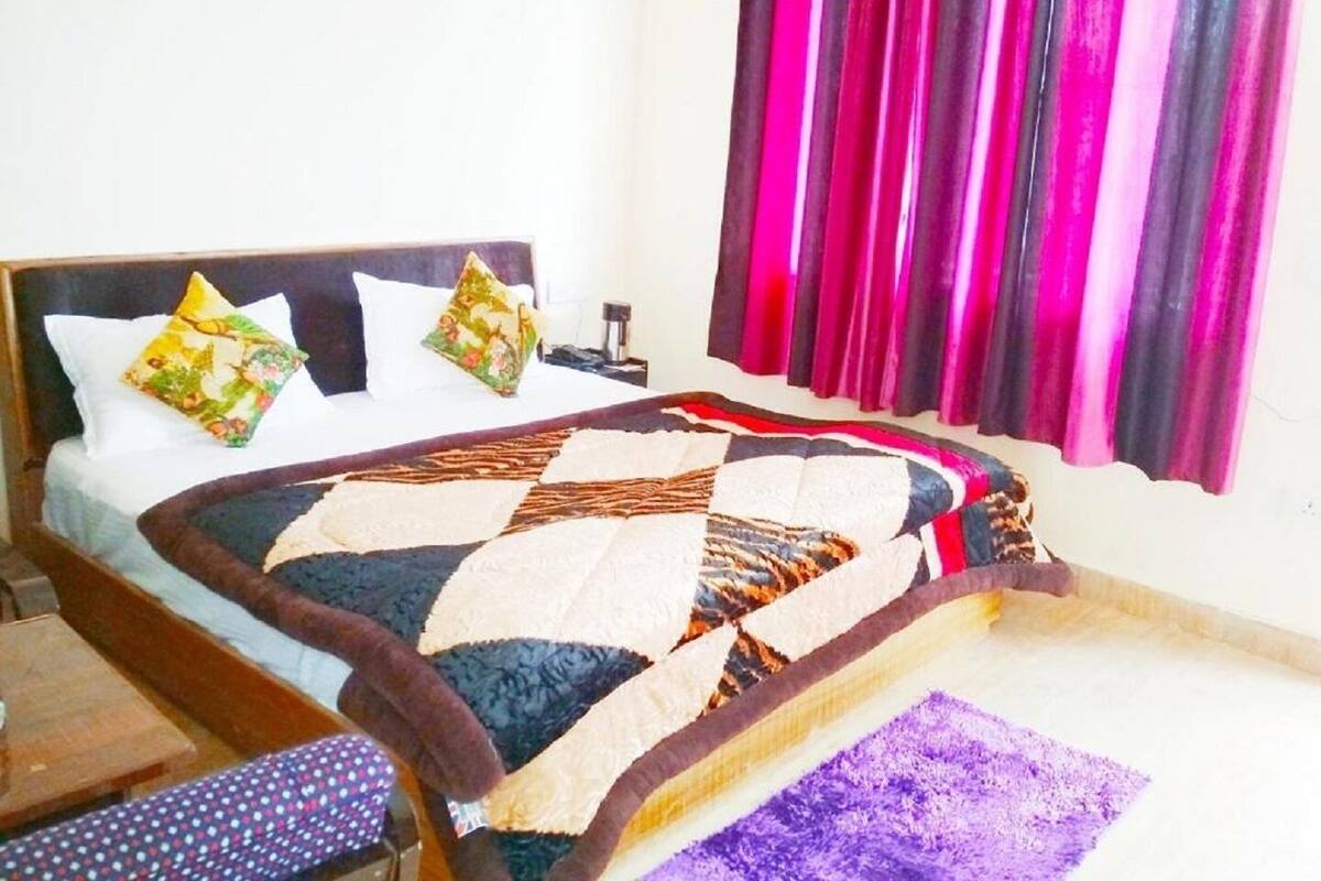 A bed with a quilt, pillows, and a nightstand.