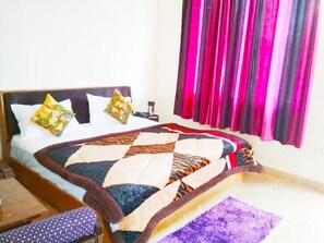 A bed with a quilt, pillows, and a nightstand.