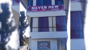 Un bâtiment sur lequel on peut lire l’inscription : « Silver Dew Resorts Hotel & Restaurant ».