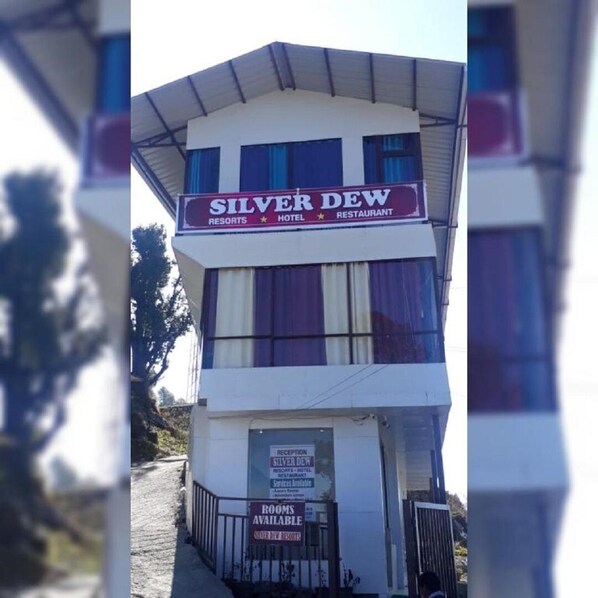 A building with a sign reading "Silver Dew Resorts Hotel & Restaurant."