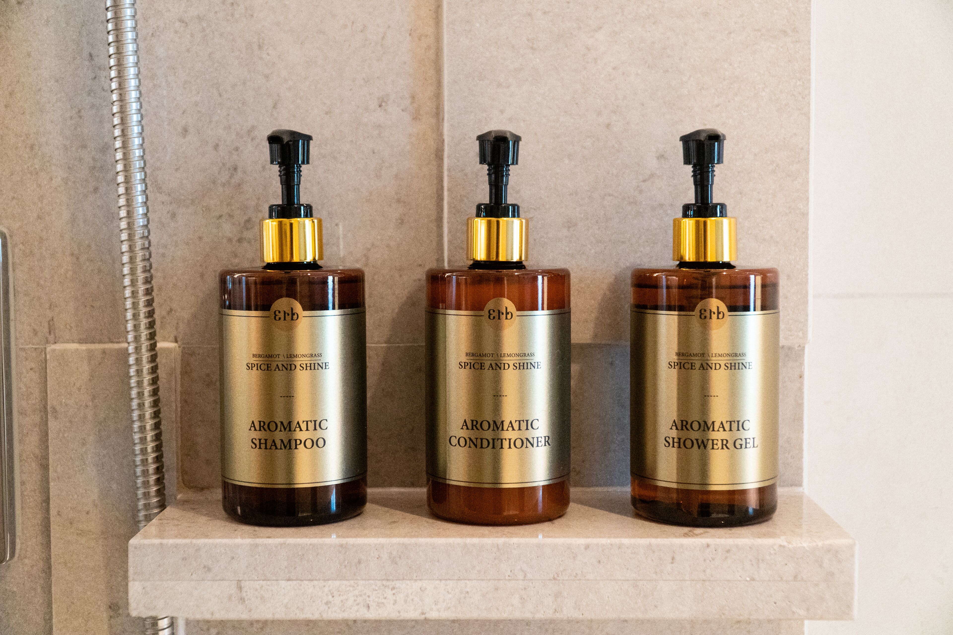 Three bottles of aromatic products on a shelf.