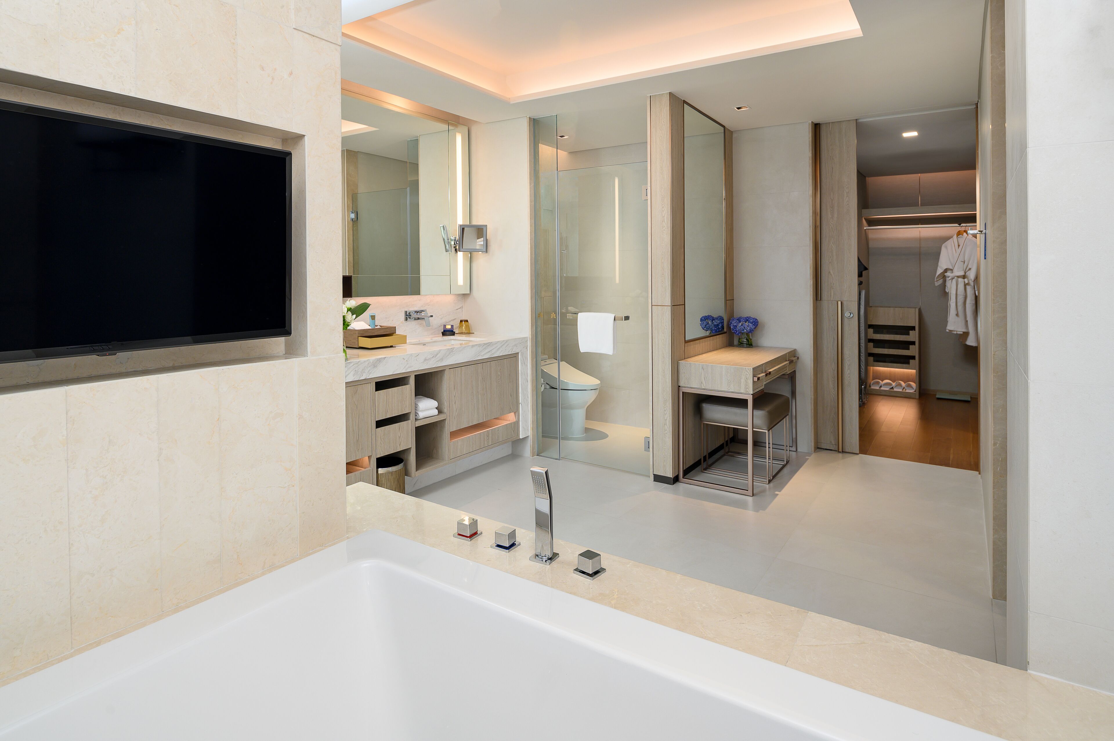 Une salle de bain moderne dotée d’une grande baignoire, d’une douche à parois de verre et d’un meuble-lavabo avec un miroir.