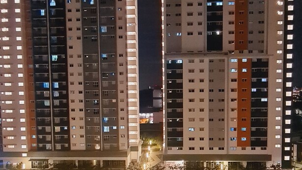 A nighttime view of a residential building complex with multiple high-rise apartments, a swimming pool, and well-lit pathways. - Anjung Apartment 3BR 1 (Banting)