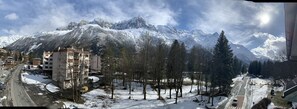 A snow-covered mountain range with a town in the foreground, featuring buildings and a road. - Hôtel des Lacs (Chamonix-Mont-Blanc)