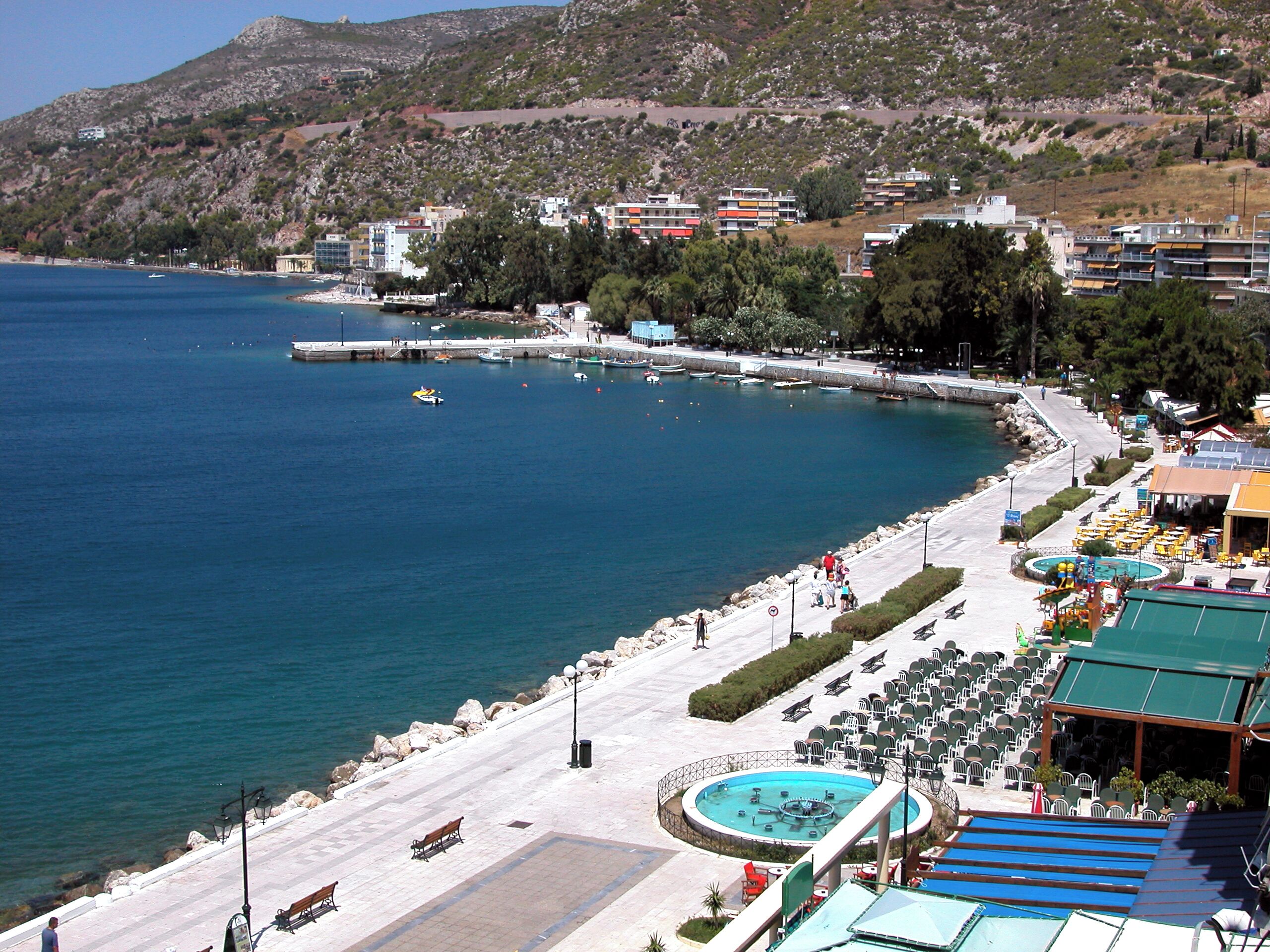A coastal hotel with a pool, outdoor seating, and a view of the sea.