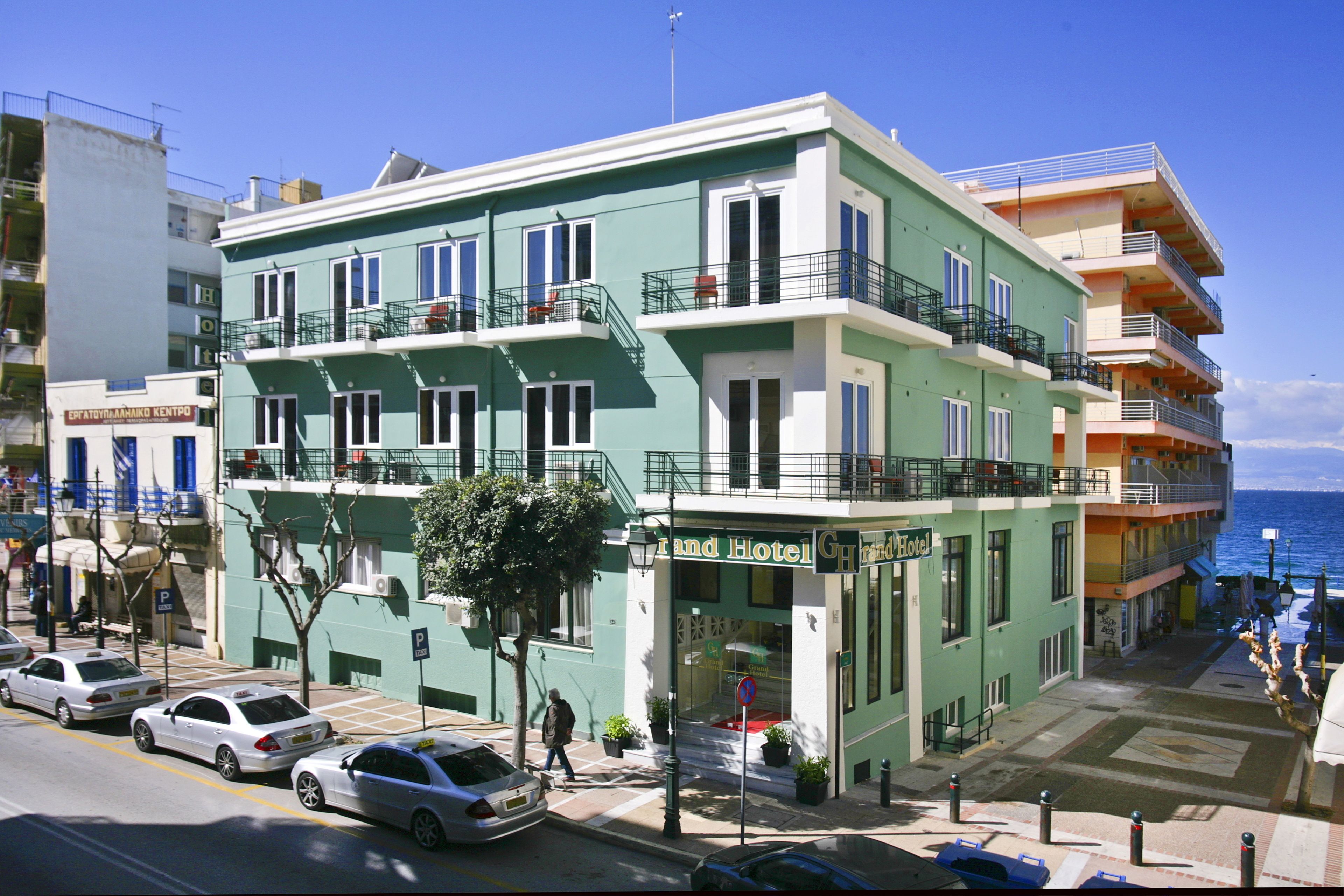 Un hôtel à plusieurs étages, doté de balcons, d’une entrée bien visible et d’un espace de stationnement.