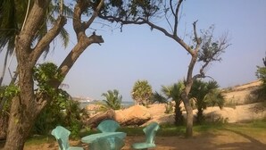 A natural outdoor seating area with a view of the ocean. - Redhill Yala (Kirinda)
