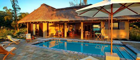 Piscine extérieure, parasols de plage, chaises longues