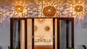 Une chambre à coucher avec un lit en bois, un miroir et une décoration murale.