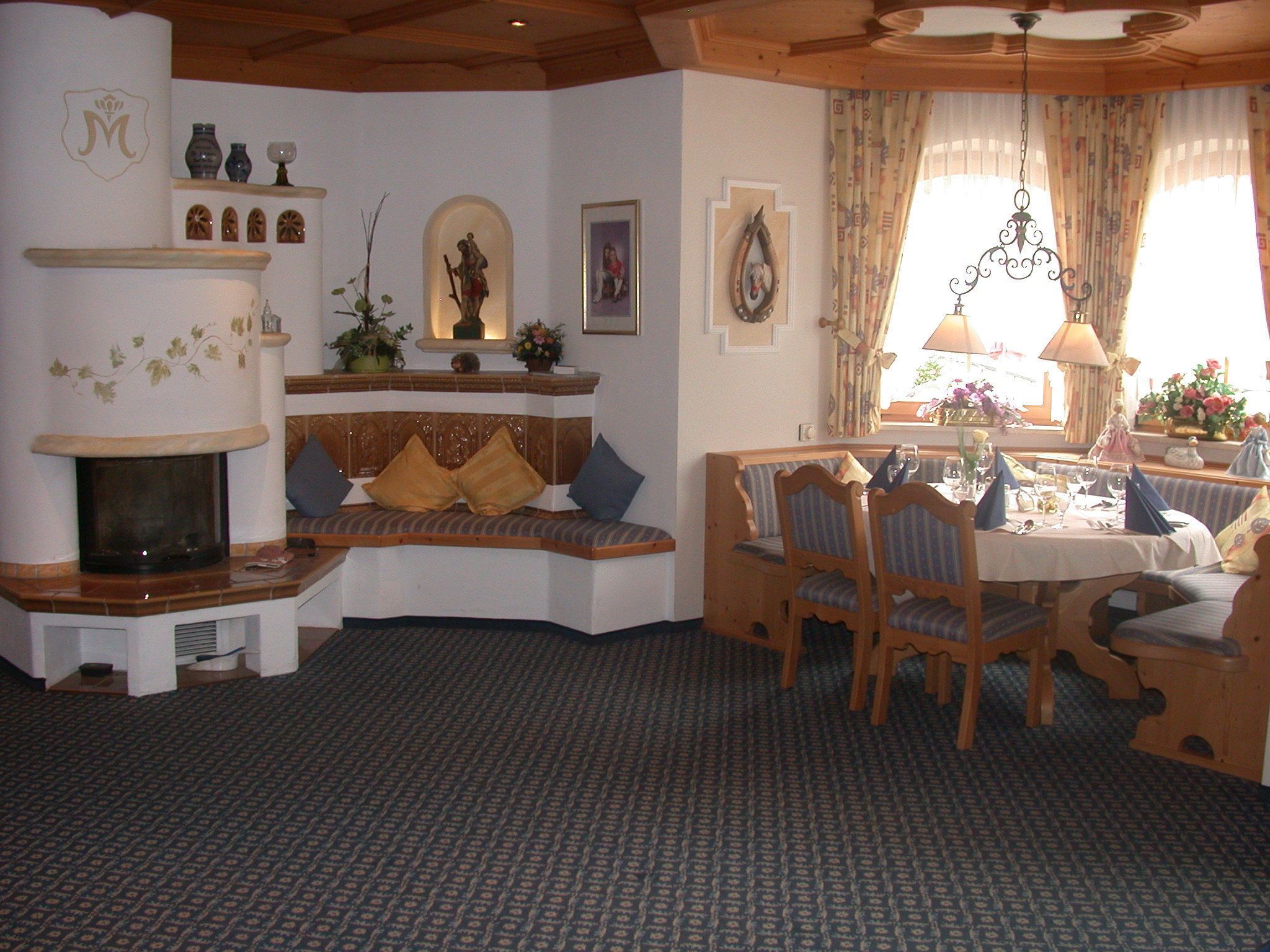 A cozy living room with a fireplace, a dining area with wooden furniture, and decorative items on the walls.