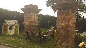 Ein Park mit einer kleinen Backsteinarchitektur, einer Bank und einem Tisch.