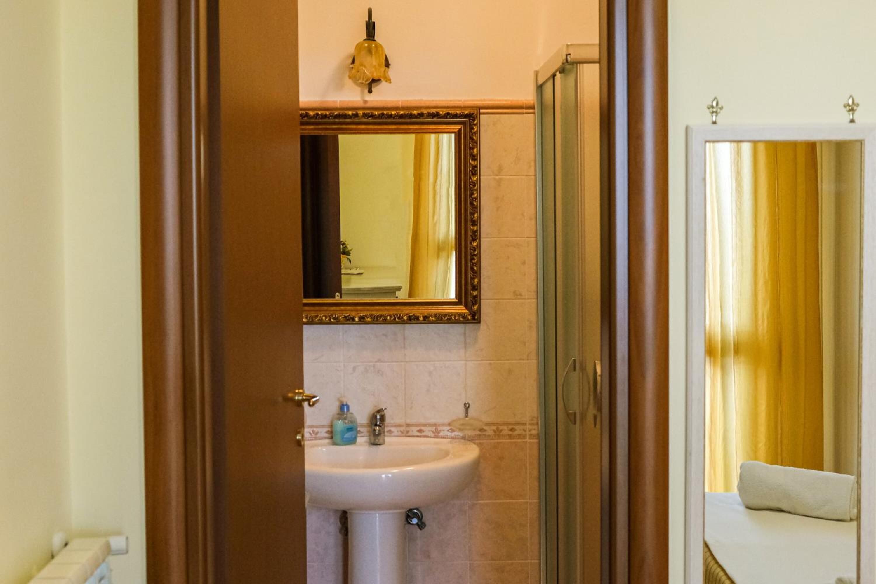 A bathroom with a sink, mirror, and shower.