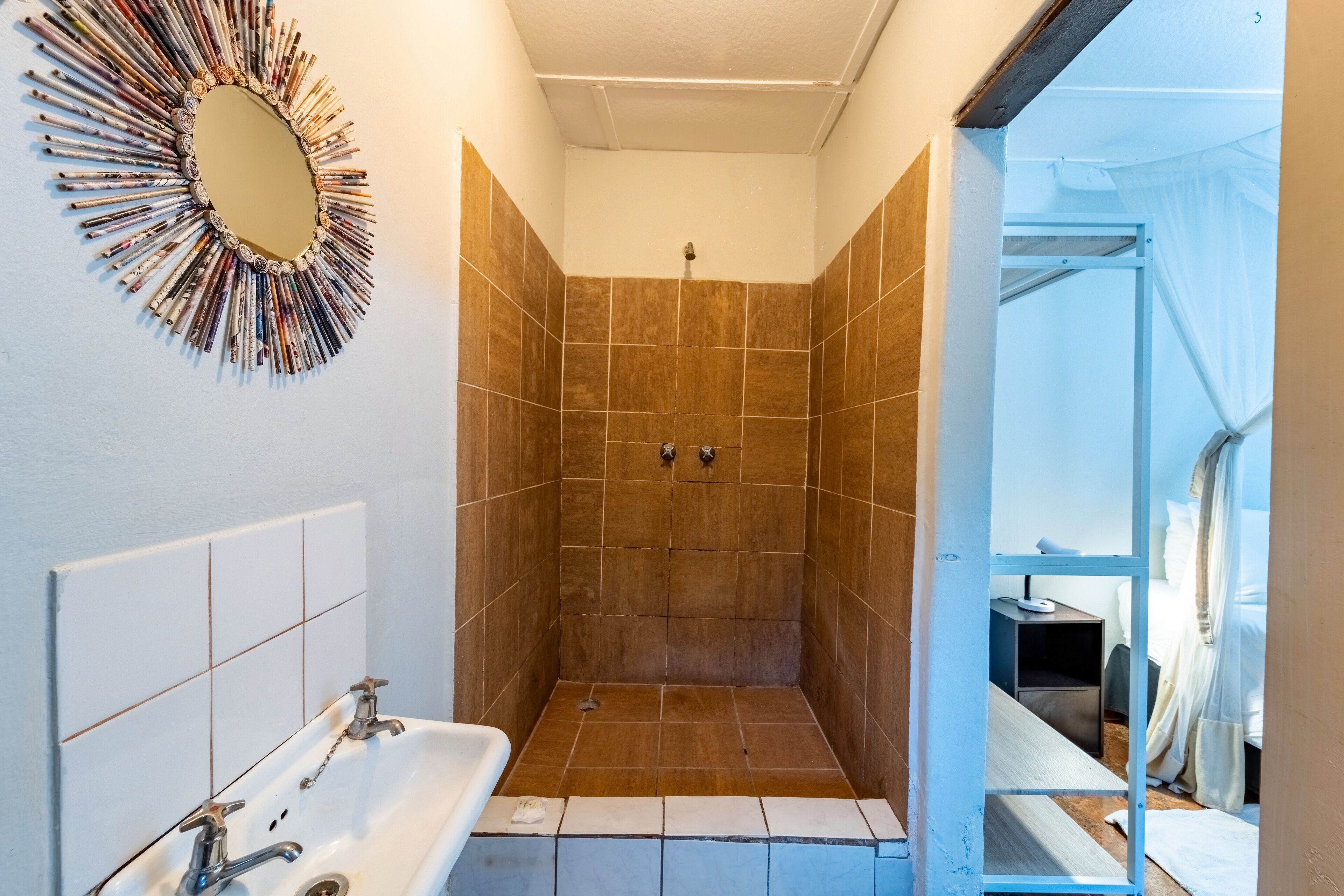 A bathroom with a shower, a sink, and a mirror.