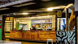 Eine Bar mit Holztresen und einem Schild, das daraufhinweist, dass nur bargeldlose Zahlungen akzeptiert werden.