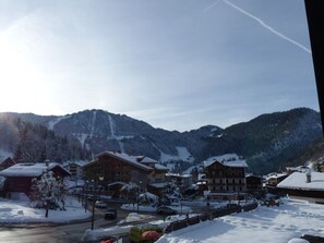 A snow-covered mountain town with wooden buildings, a clear sky, and a ski slope in the background. - 2-Bedroom Duplex near Ski Slopes, Central Village, Parking, Balcony, La Clusaz (La Clusaz)