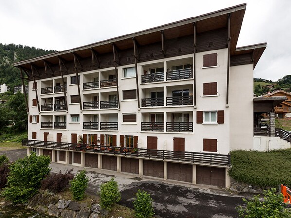 A multi-story hotel with balconies and a stone facade.