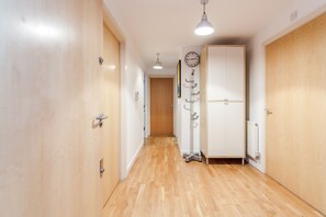 Stylish hallway with doors leading to individual rooms, a spacious wardrobe, and a clock for keeping track of time.