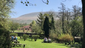 A park with picnic tables and people sitting. - Calf's Head Hotel (Clitheroe)