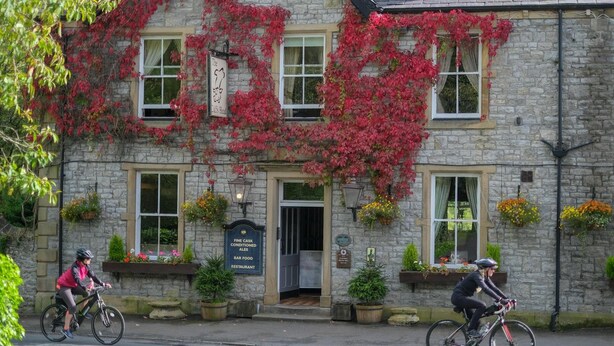 A stone building with ivy, a sign reading "The Goat's Head," and a signboard listing "Fine Cask Conditioned Ales, Bar Food, Restaurant." - Calf's Head Hotel (Clitheroe)