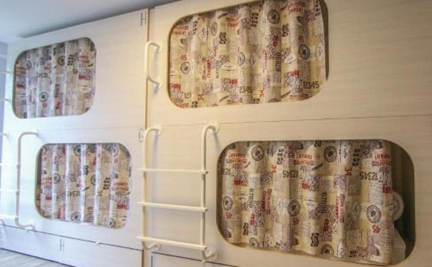 Pared con tres vanos que parecen ventanas, cada uno con una escalera que lleva a un nivel superior.