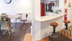 Une cuisine moderne avec un coin bar, une horloge et un extincteur.