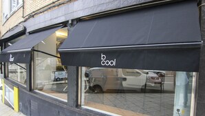 Une devanture de magasin avec des auvents sur lesquels on peut lire « b cool ».