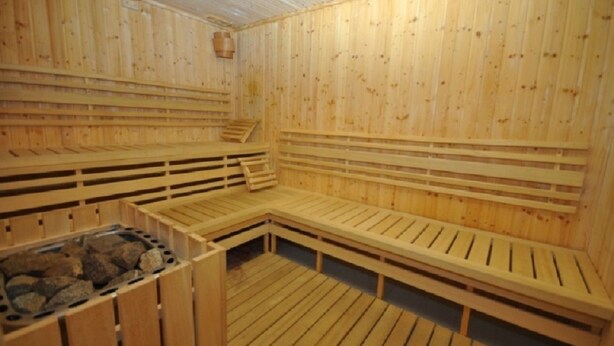 A wooden sauna with benches and a stone-filled basin. - Apartmány Pod Zálesím (Loucna nad Desnou)