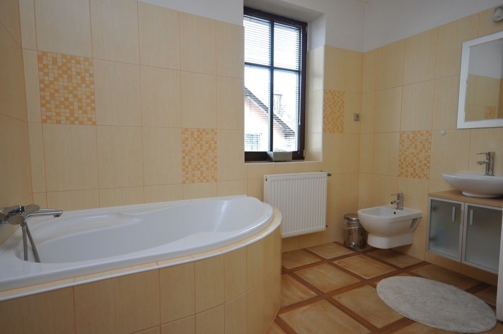 Un baño con bañera, lavamanos y ventana.