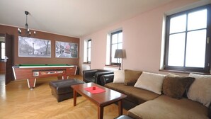 A living room with a pool table, a sofa, a coffee table, and a lamp. - Apartmány Pod Zálesím (Loucna nad Desnou)