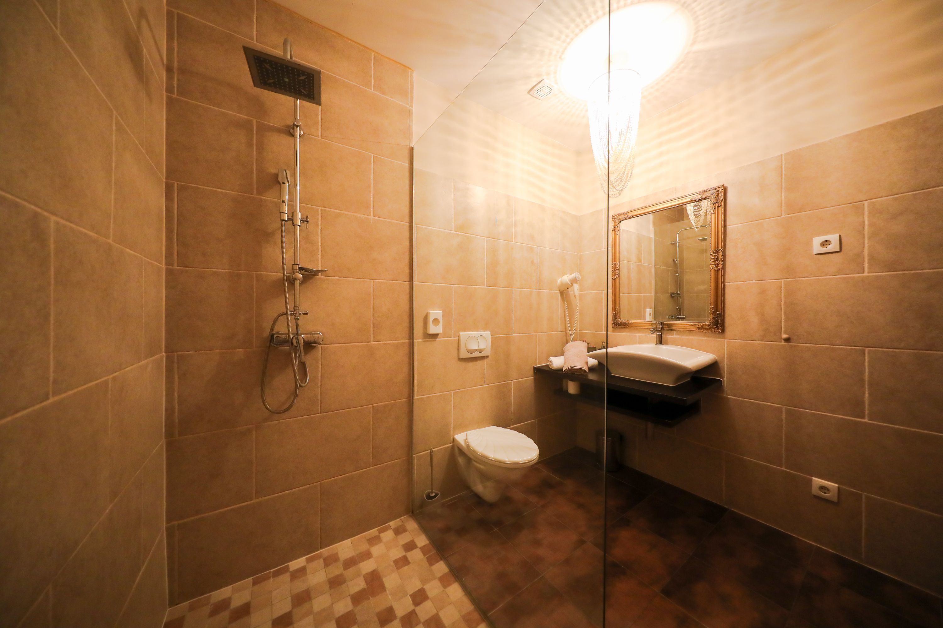 A bathroom with a shower, toilet, sink, and mirror.