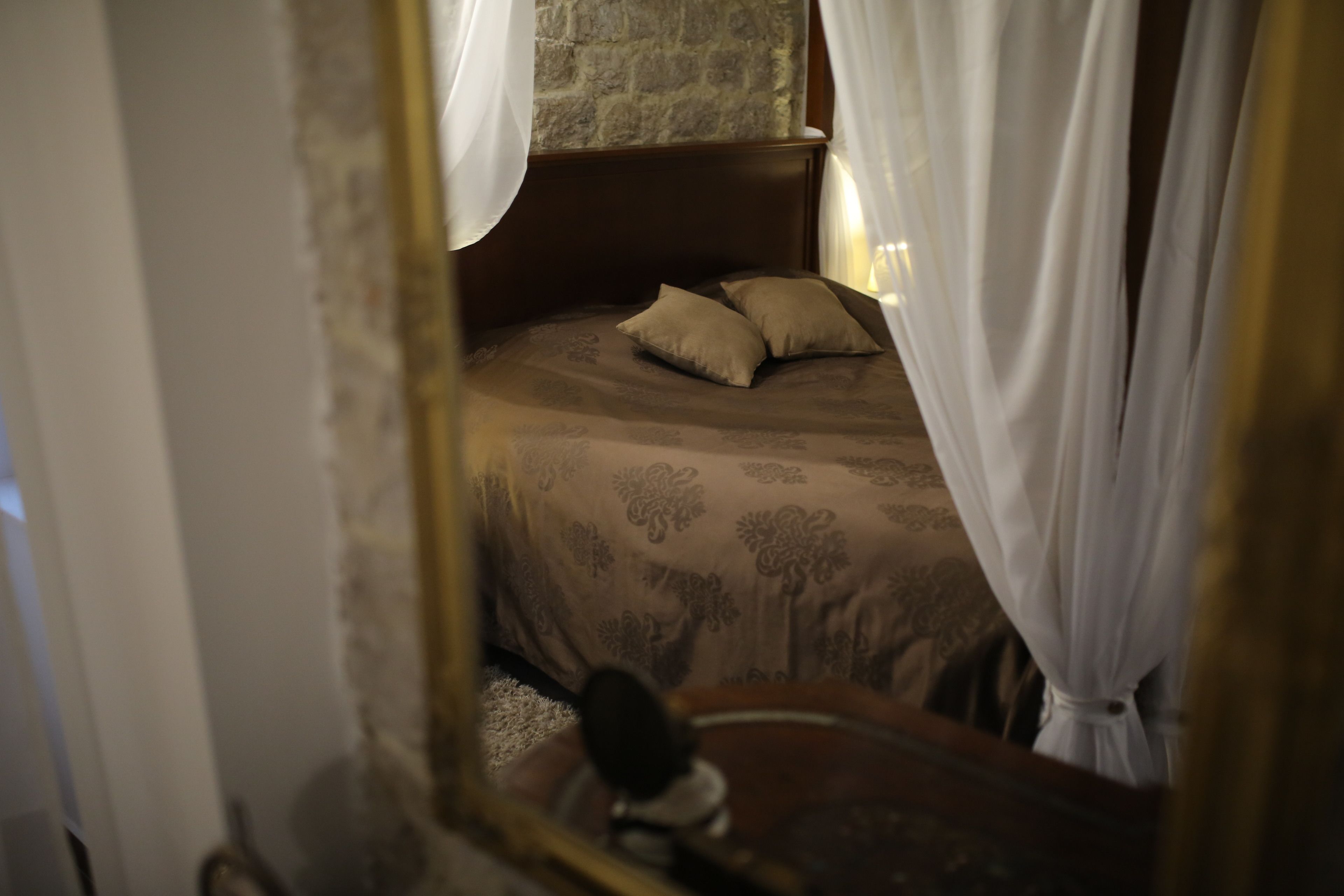 Une chambre à coucher avec un lit, une tête de lit et un miroir.