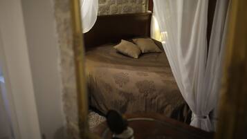 Une chambre à coucher avec un lit, une tête de lit et un miroir.