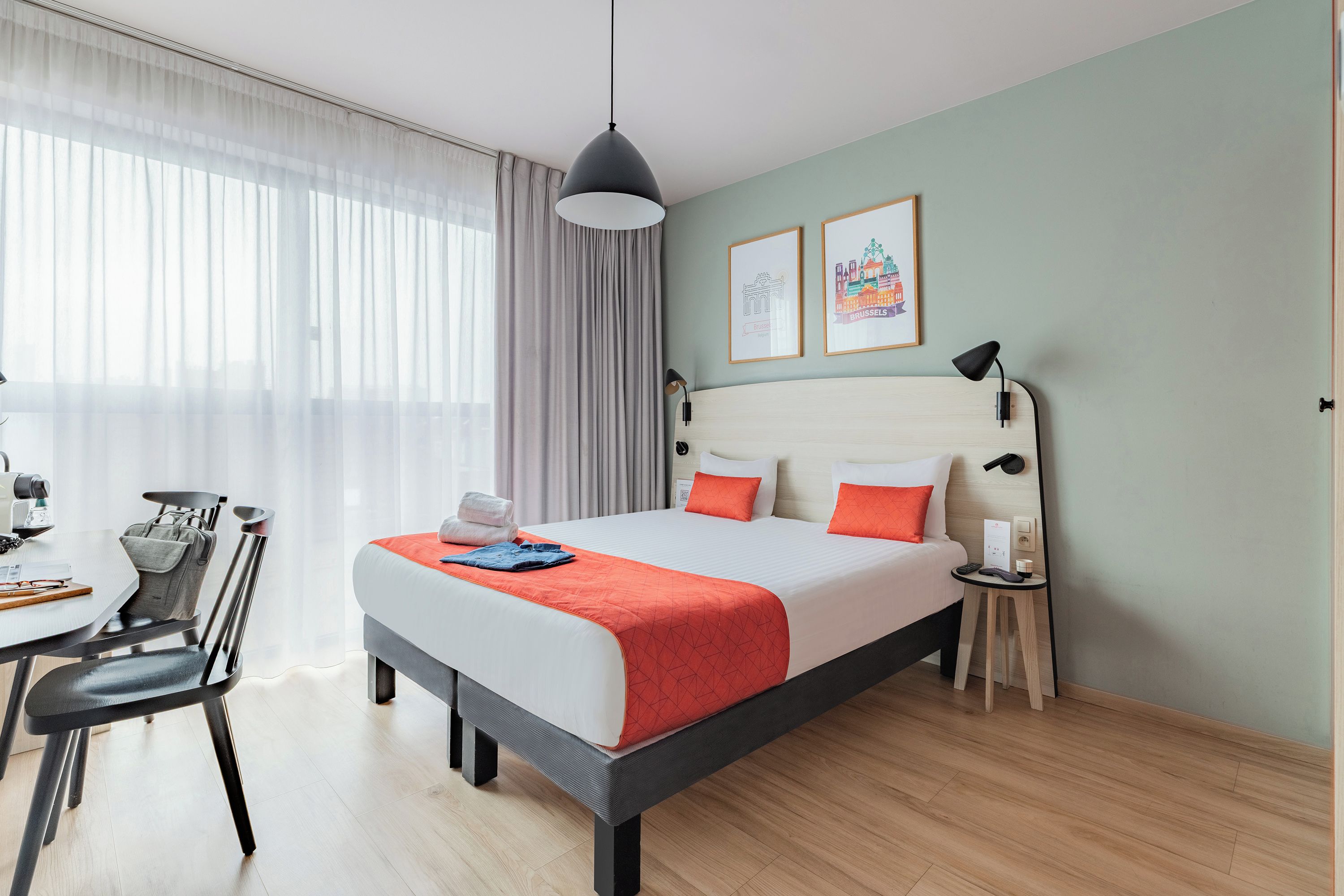 Una habitación de hotel con una cama, un escritorio y una silla.
