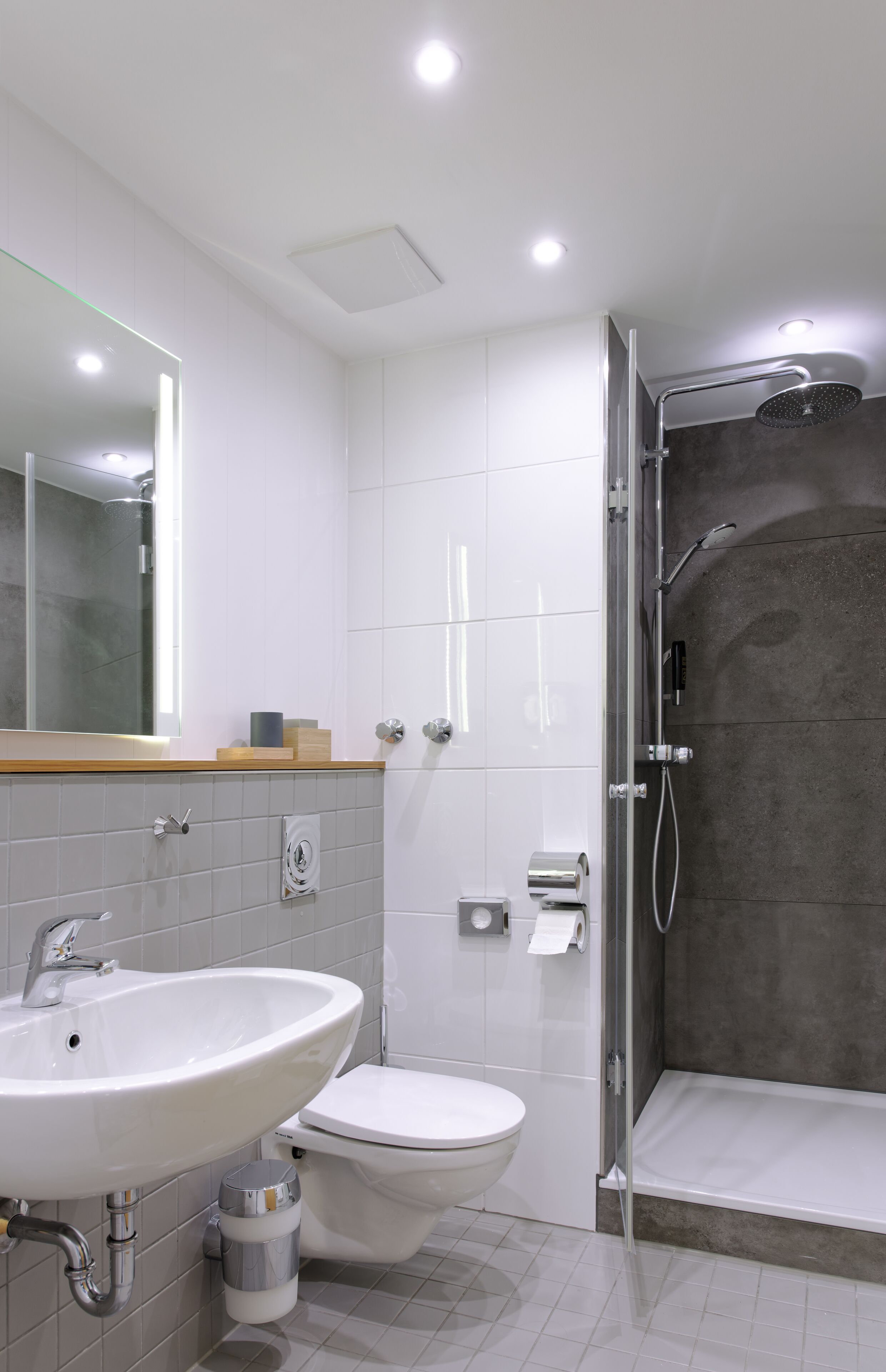 Un baño moderno con lavamanos, inodoro y ducha.