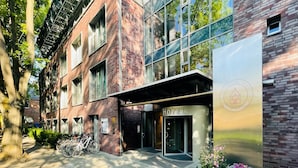 A hotel with a brick facade, large windows, and a sign reading "HOTEL AM KLOSTER". - Hotel Am Kloster (Werne)