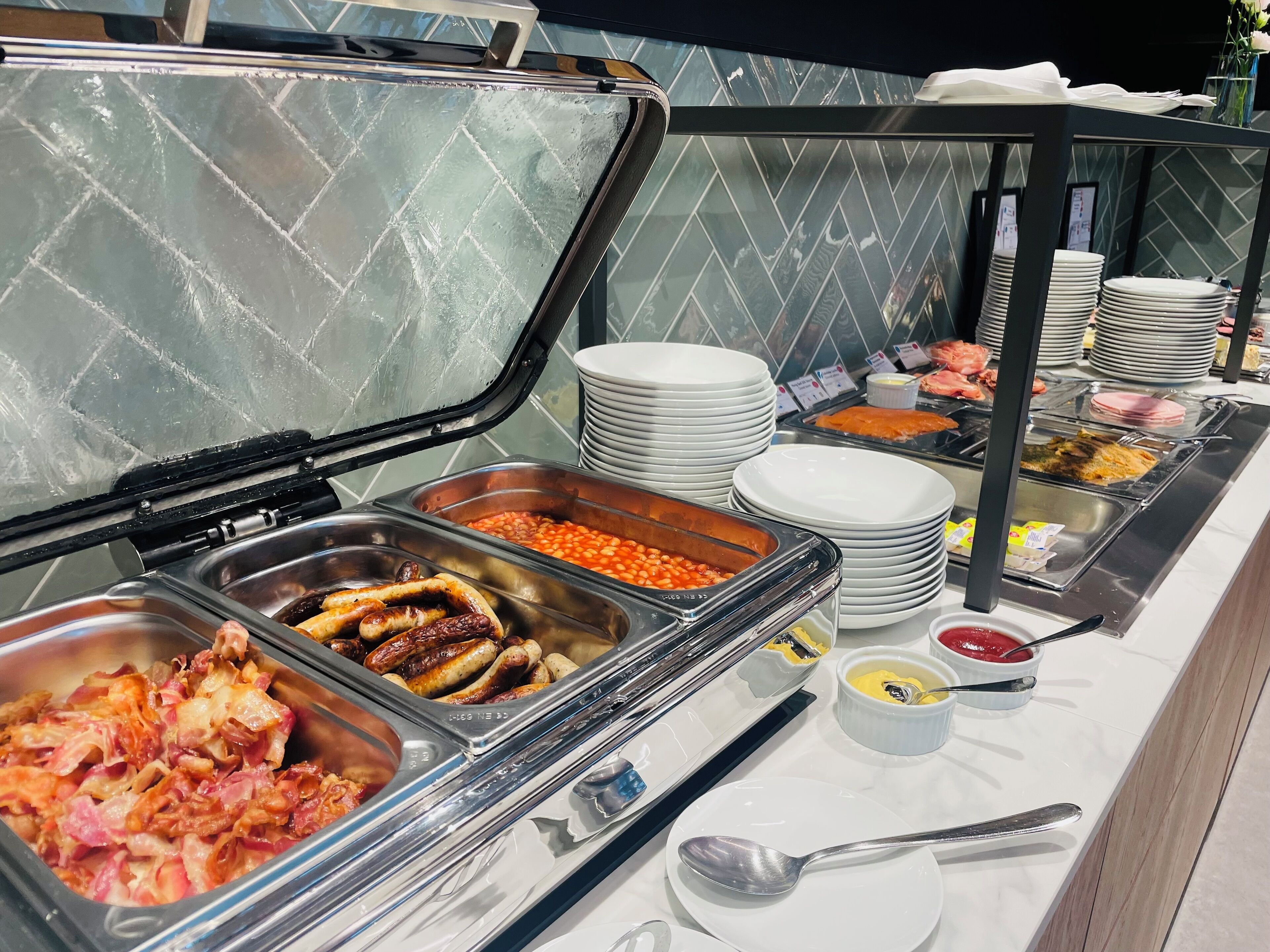 A buffet with various food options including sausages, beans, and salads.