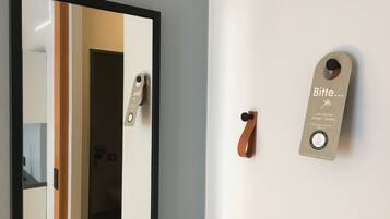 A hotel room with a door, a wall-mounted handle, and a sign with instructions.