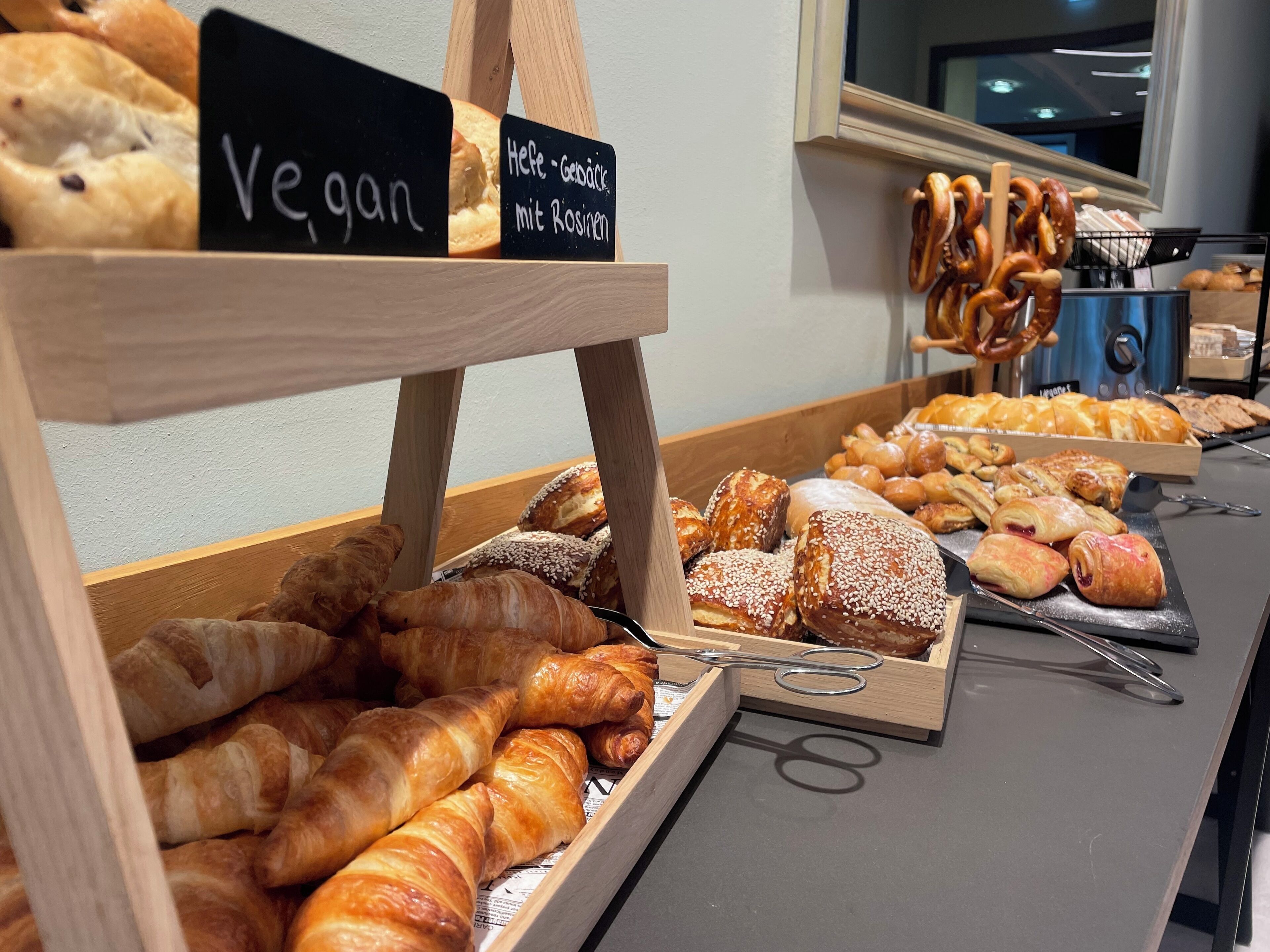A bakery display with various baked goods, including vegan options.