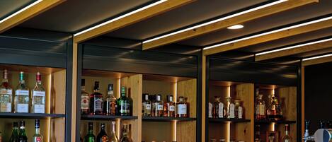 A bar with wooden shelves stocked with various liquor bottles and glasses.