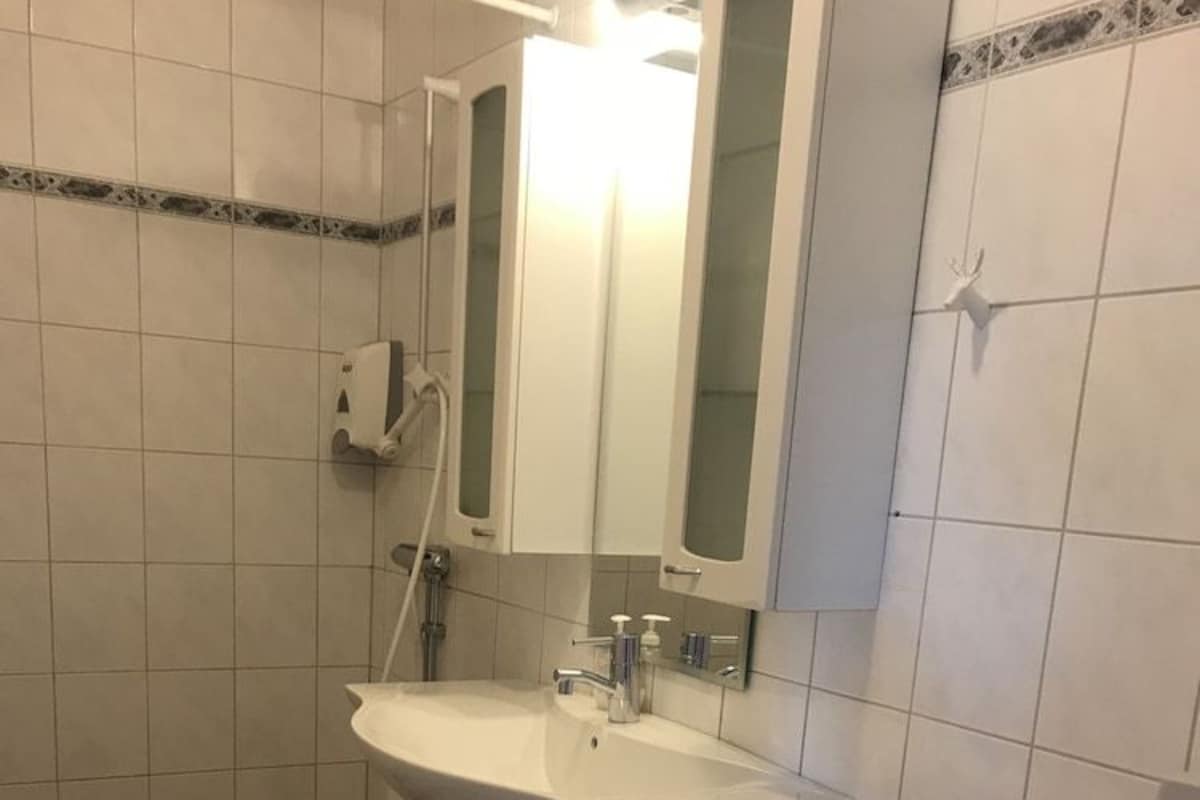 A bathroom with a toilet, sink, and mirror.