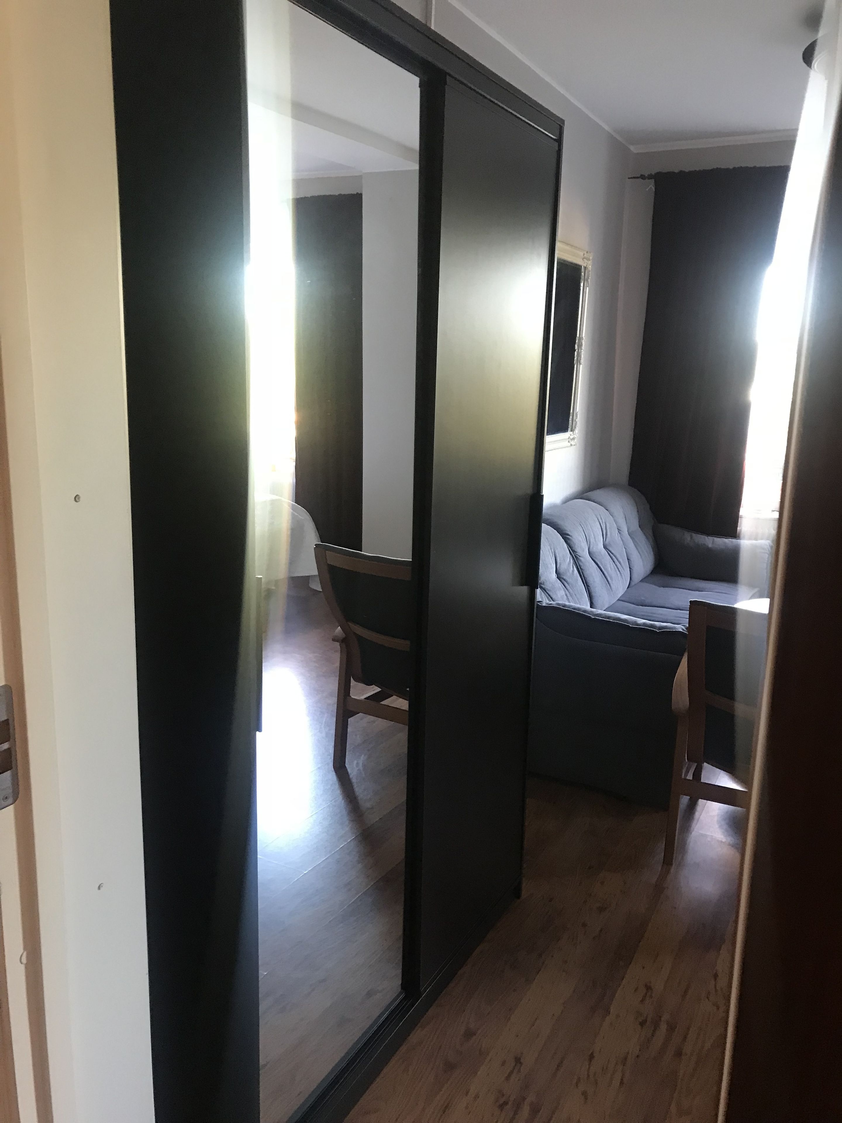 Ein modernes Zimmer mit Schiebetür, einer Couch, einem Sessel und einem kleinen Tisch.