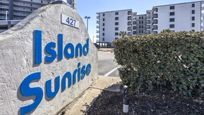 A sign for "Island Sunrise" with a number "427" above it, indicating a property or location.