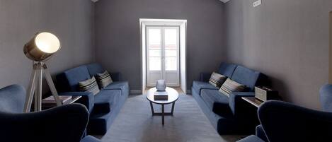 A modern living room with two sofas, a coffee table, and a floor lamp.