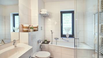 Un baño moderno con bañera, inodoro y lavamanos.