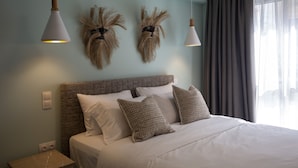 Une chambre à coucher moderne avec un grand lit, deux appliques murales et un élément décoratif fixé au mur.