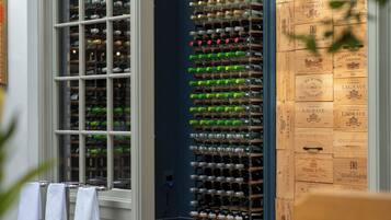 Una bodega con múltiples estanterías para vino y cajas de madera etiquetadas con nombres y añadas.