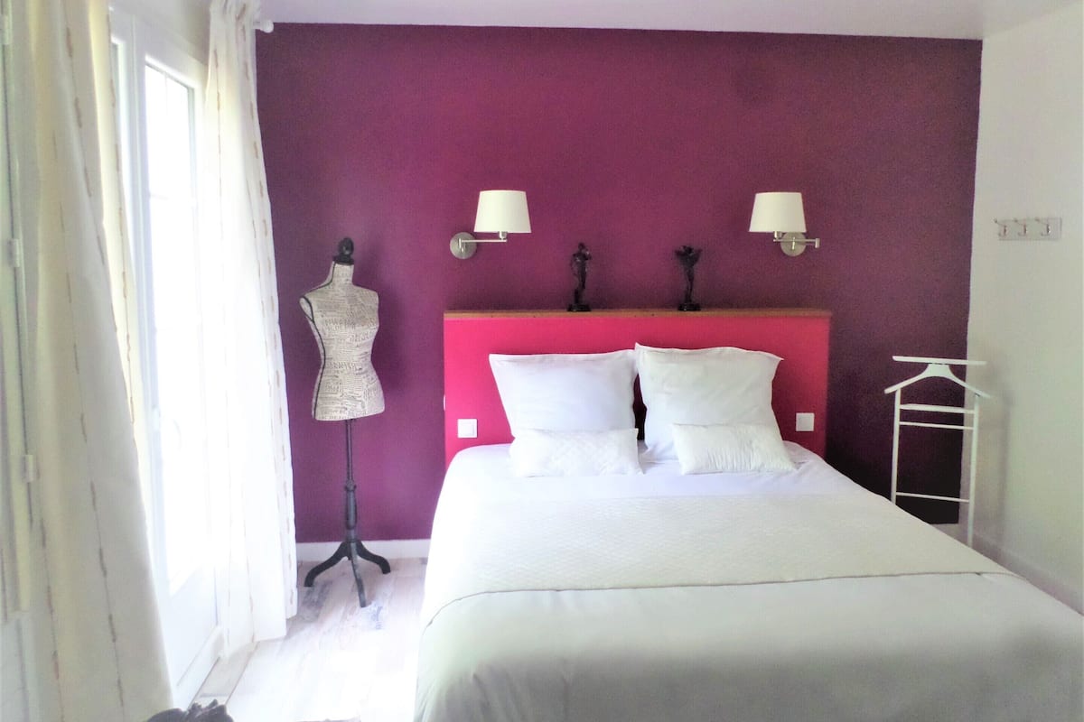 Un dormitorio con una cama, un maniquí y una lámpara de escritorio.