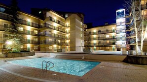 A multi-story hotel with a swimming pool surrounded by a brick patio. - Vantage Point 210 3 Bedroom Condo by RedAwning (Vail)