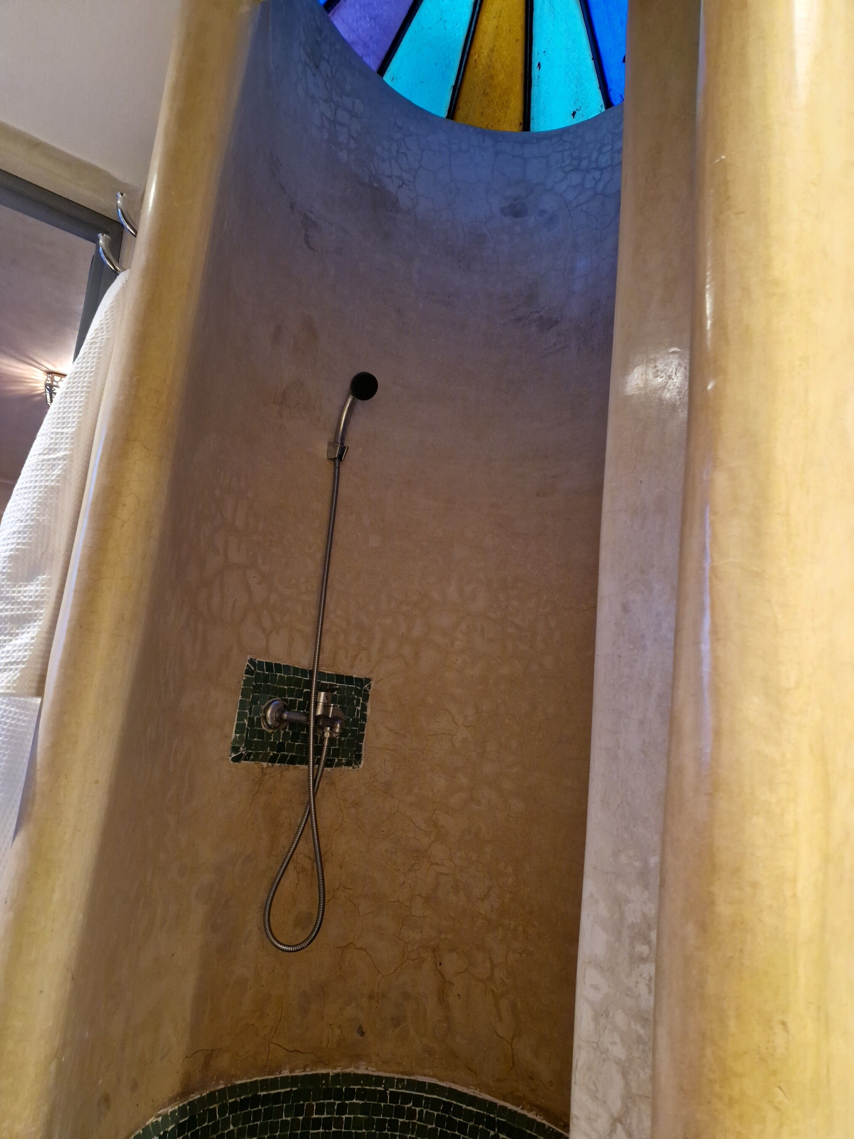 Una ducha con cabezal de ducha de mano y panel de control en la pared.