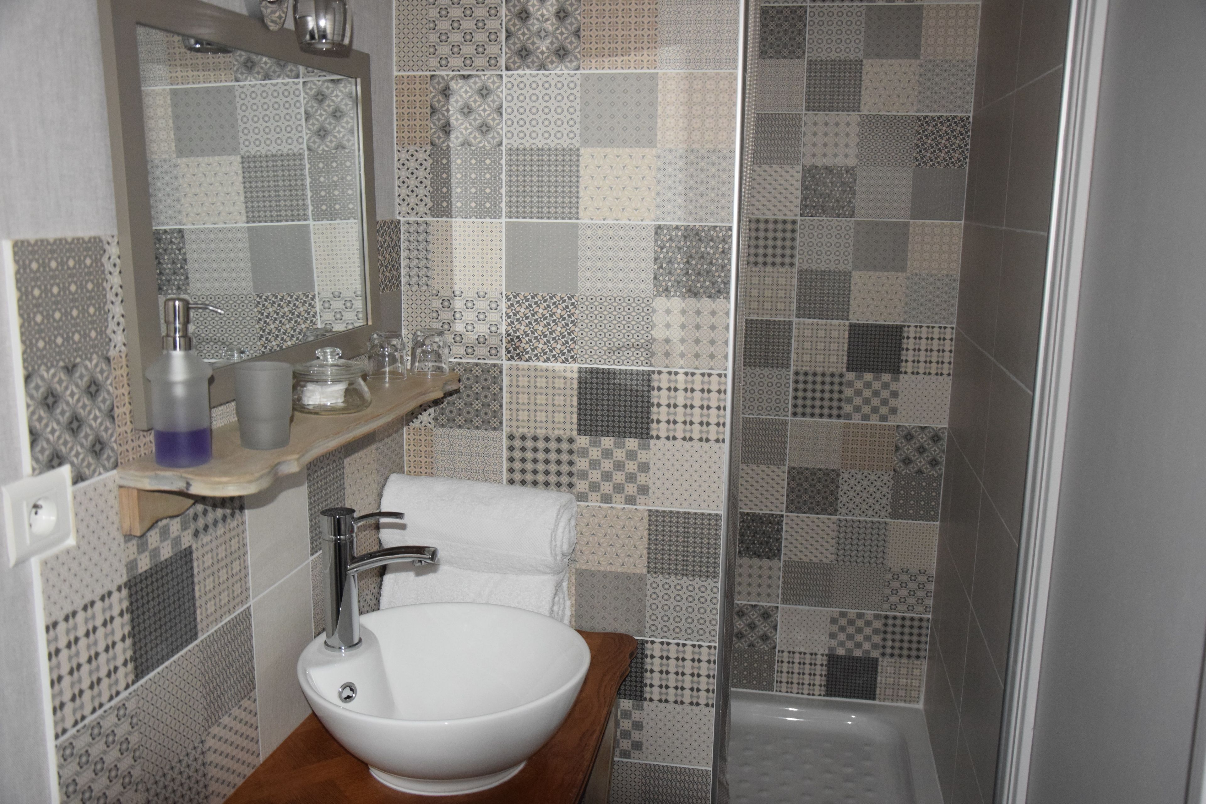 A bathroom with a white sink, mirror, and shower.
